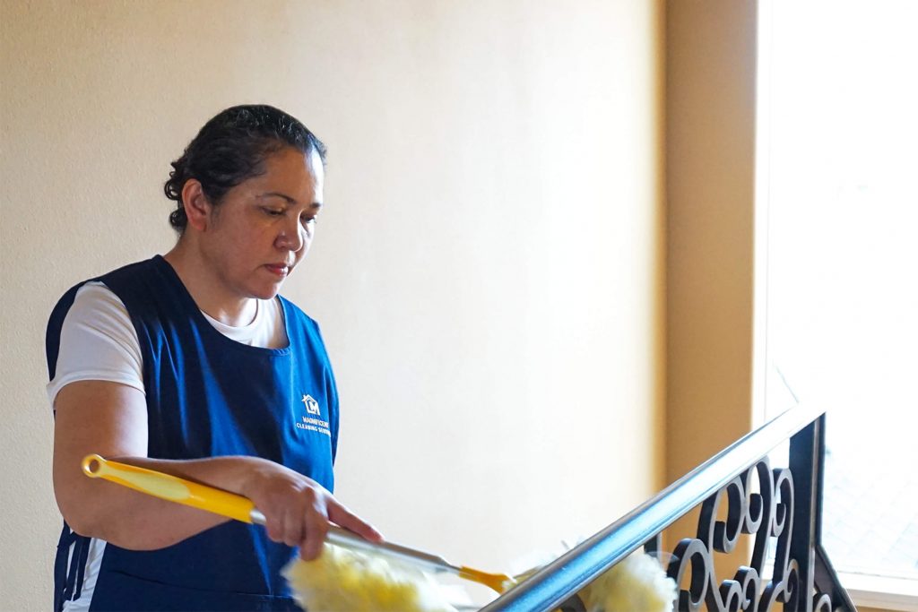 Magnificent cleaner dusting a home during a professional cleaning visit
